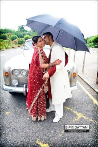 couple portraits by photographer on a rainy day at Oshwal Centre Potterbar