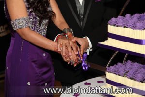 A close-up photo od couple cutting wedding cake