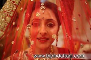 indian bride getting ready with makeup artist and wedding dress photo by Bipin Dattani